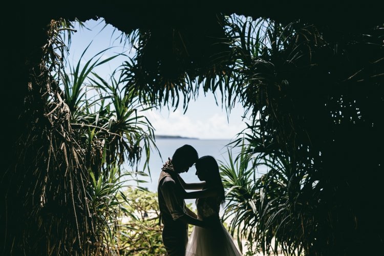 海をのぞむ緑の中で抱き合う新郎新婦