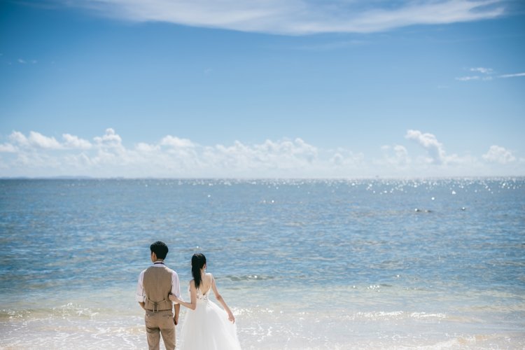 大きくて綺麗な海を眺める新郎新婦後ろ姿