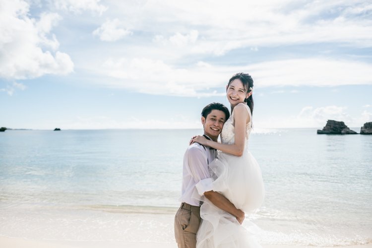 海辺で新郎に抱き上げられる新婦