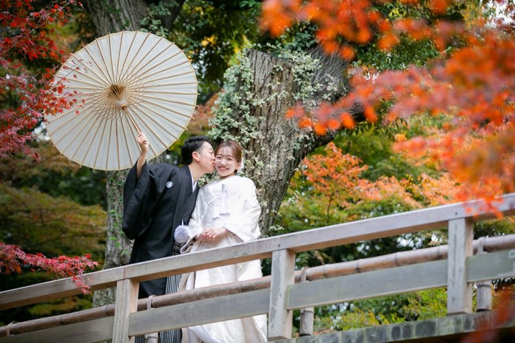 橋の上でキスをしているウェディングフォト